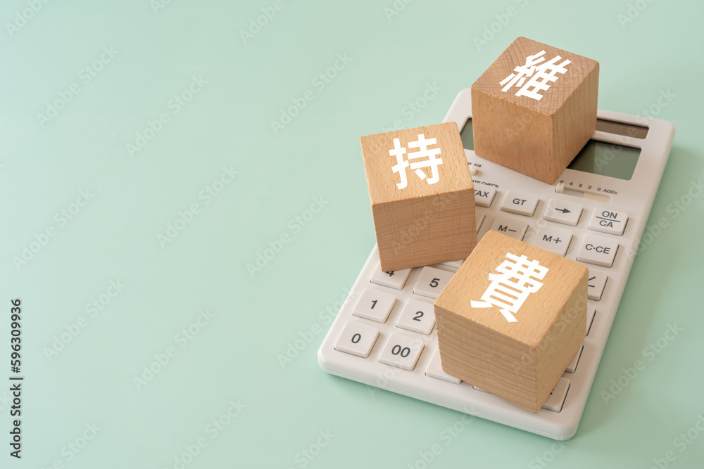 Obraz premium 維持費と書かれたブロックと電卓