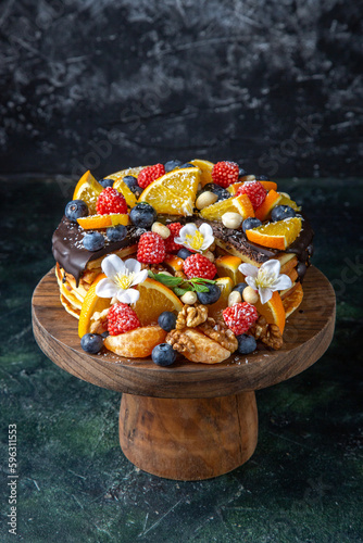 front view delicious fruit cake with chocolate syrup on round wooden desk dark background pie dough biscuit sugar sweet dessert tea cakes