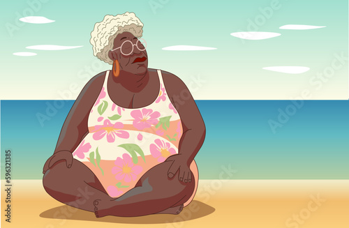 Older Afro woman sitting on the beach in summer.