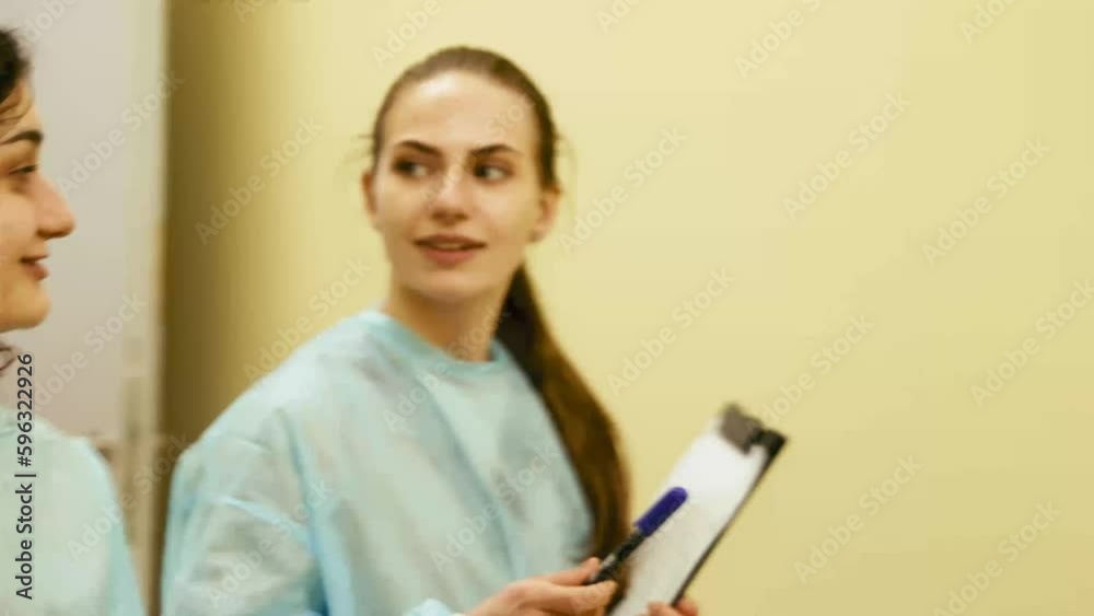 Female surgeon, vet and assistant cheerfully talking after successful surgery, operation. Taking care after pets health, medical care. Concept of veterinary clinic, animal, health, care, treatment Female surgeon, vet and assistant cheerfully talking after successful surgery, operation. Taking care after pets health, medical care. Concept of veterinary clinic, animal, health, care, treatment