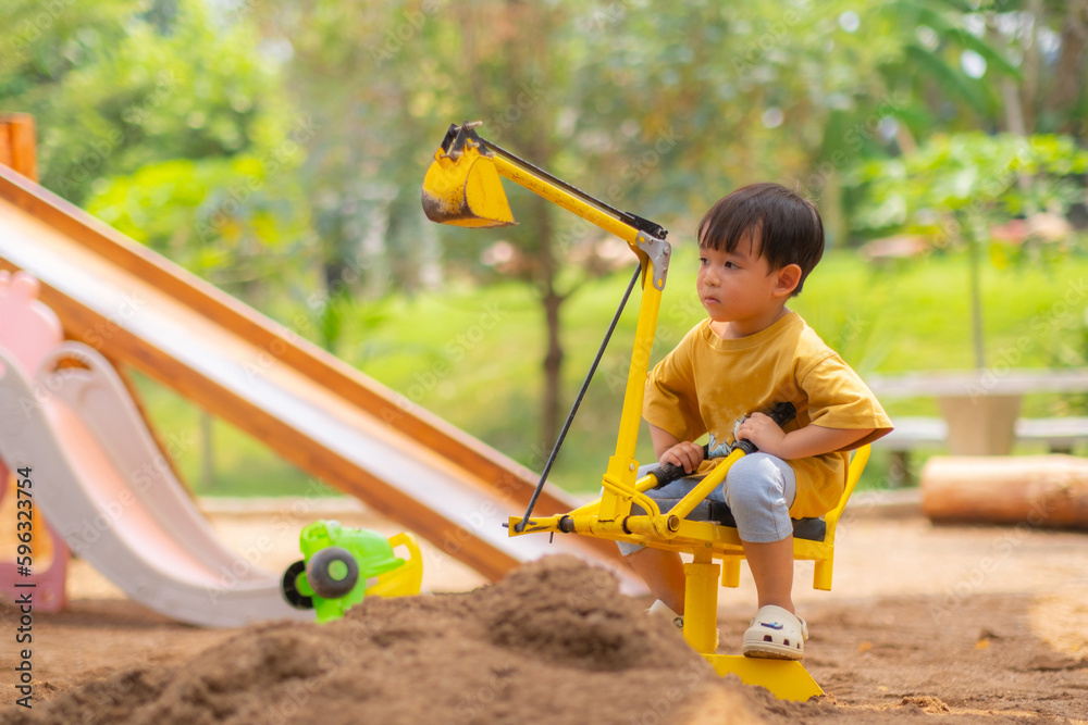 Kid baby boy todler playing construction truck toy diging sand in playground Kid baby boy todler playing construction truck toy diging sand in playground