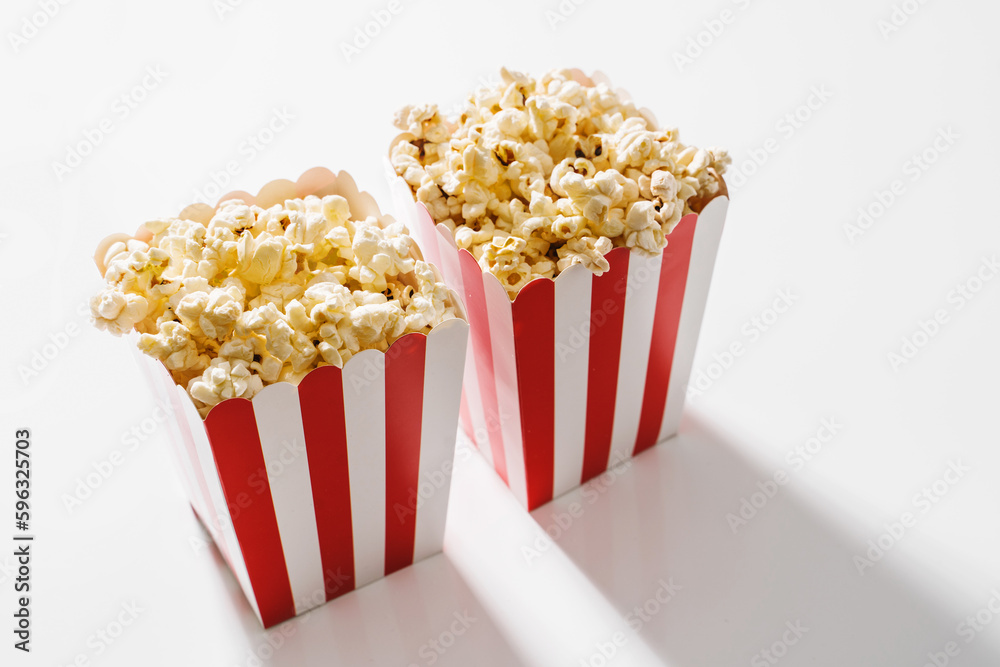 Classic striped buckets with delicious popcorn on white background