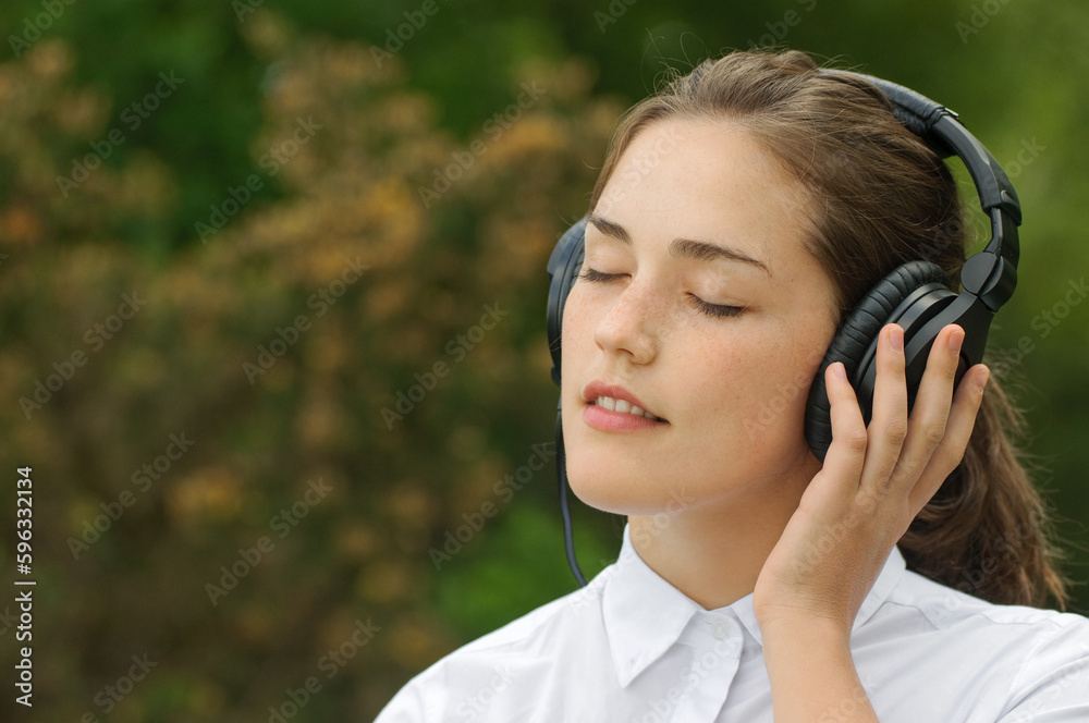Music gets the best of me. Shot of a young woman listening to music in the park. Music gets the best of me. Shot of a young woman listening to music in the park.