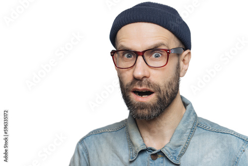 Foto Suprised terrified unshaven male stares at camera and keeps mouth widely opened,