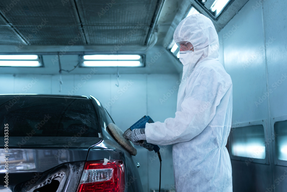 Mechanic man works with grinding tool. Sanding of car elements. Garage painting car service repair and maintenance Mechanic man works with grinding tool. Sanding of car elements. Garage painting car service repair and maintenance