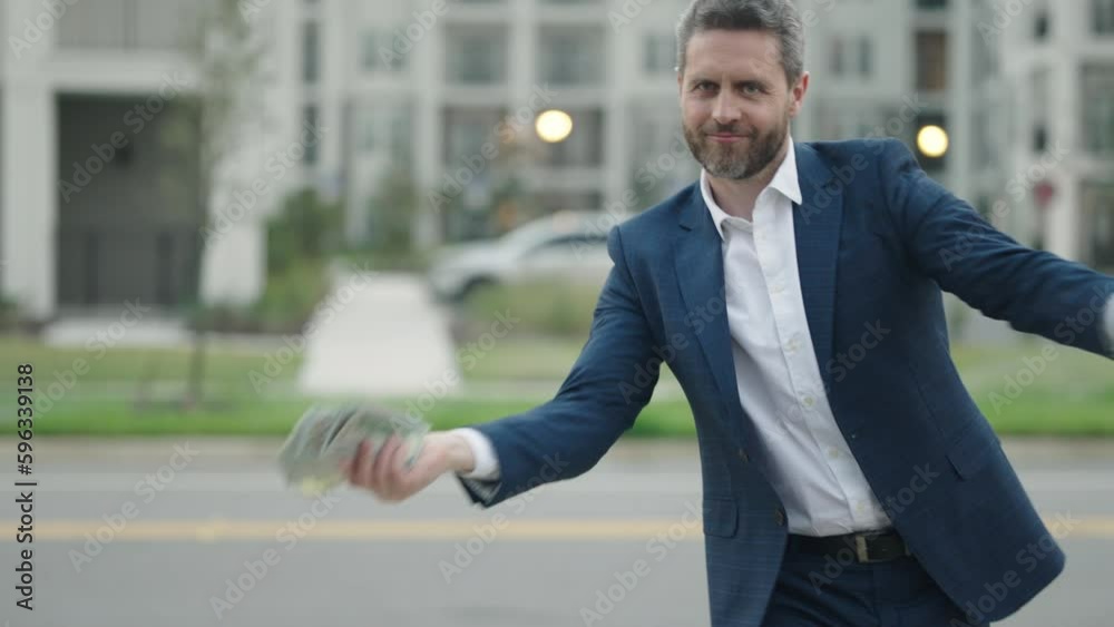 Business man hold money outdoor. Rich man in suit with money dollar bills. Successful businessman with dollar banknotes. Slow motion. Rich millionaire in suit holding money. Business man hold money outdoor. Rich man in suit with money dollar bills. Successful businessman with dollar banknotes. Slow motion. Rich millionaire in suit holding money.