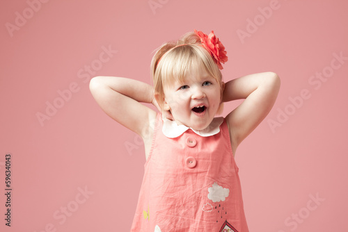 Cant wait to see what it is. Shot of a cute little girl against a studio background.