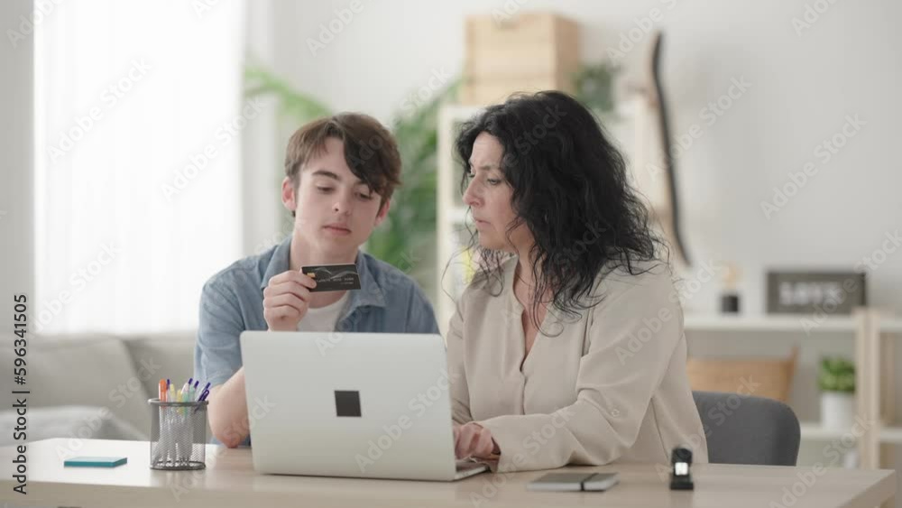 Mother and son shopping online on laptop and celebrating purchase together Mother and son shopping online on laptop and celebrating purchase together