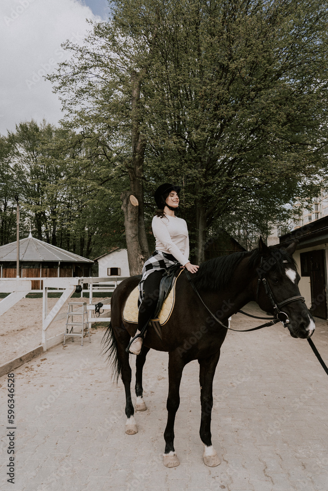 A woman instructor teaching girl how to ride a horse.  Female rider practicing on a horseback learning equestrian sport. Active lifestyle and leisure activity concep