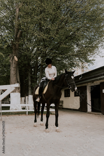 A woman instructor teaching girl how to ride a horse.  Female rider practicing on a horseback learning equestrian sport. Active lifestyle and leisure activity concep © Darius