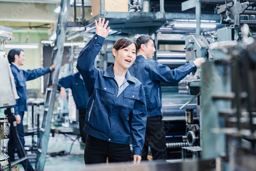 工場で手をふる女性の労働者