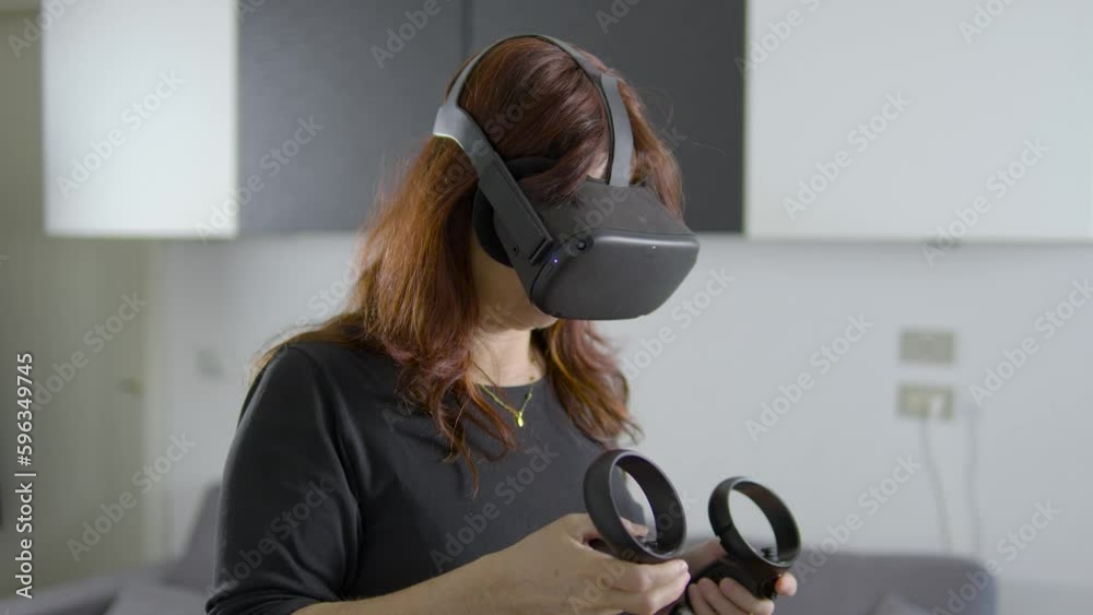 donna che usa visore di realtà virtuale in salotto