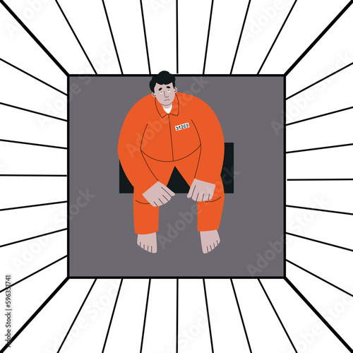 Prisoner in orange robe sits behind bars in prison and looks up sadly. Loss of freedom
