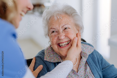 Close up of nurse stroking cheek of senior woman.