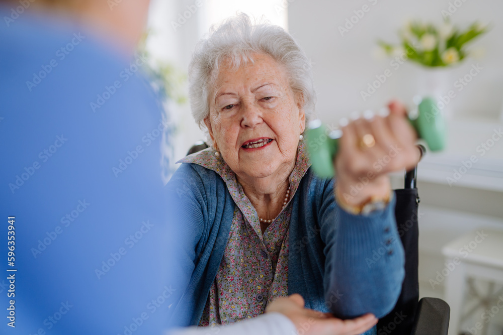 Nurse exercising with senior woman at her home, concept of healthcare and rehabilitation. Nurse exercising with senior woman at her home, concept of healthcare and rehabilitation.