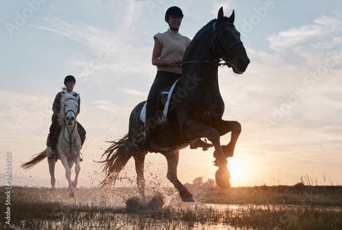 Some people go to therapy, we ride horses. Shot of two young women out horseback riding together. photo