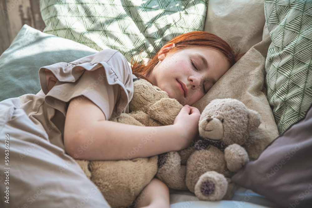 beautiful cute little girl sleeping peacefully and hugging her stuffed