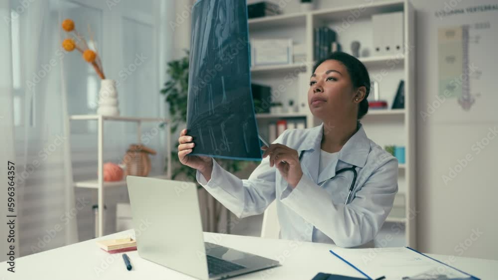 Traumatologist examining patient's x-ray image, curious case, treatment planning Traumatologist examining patient's x-ray image, curious case, treatment planning