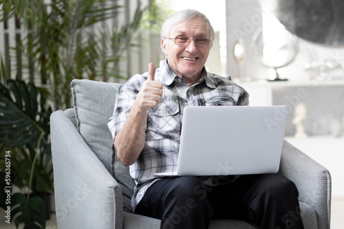 Foto Close-up portrait of old man sitting and looking at laptop