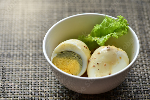 Hard-boiled eggs are placed in a white container with fresh lettuce. Healthy food concept. Increase protein. Weight control.