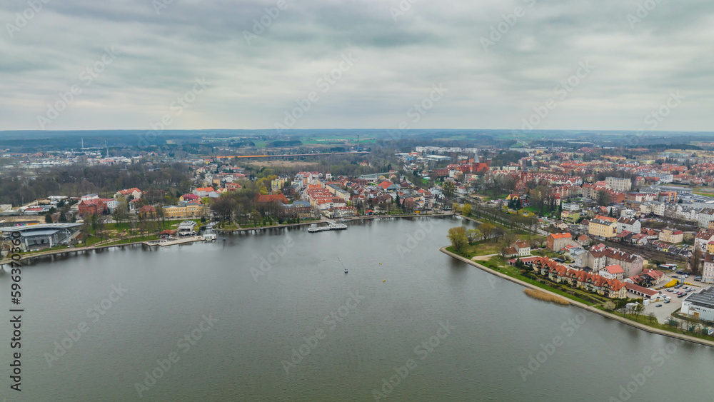 View of the Drwęckie lake and the city of Ostróda on a cloudy spring day.