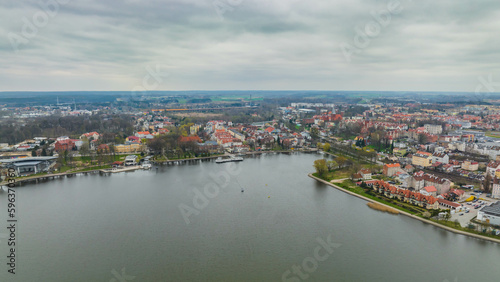 View of the Drwęckie lake and the city of Ostróda on a cloudy spring day. © Kamil