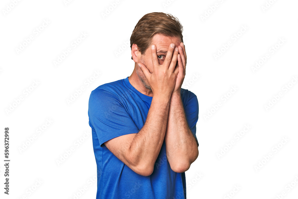 A middle-aged man isolated blink through fingers frightened and nervous. A middle-aged man isolated blink through fingers frightened and nervous.