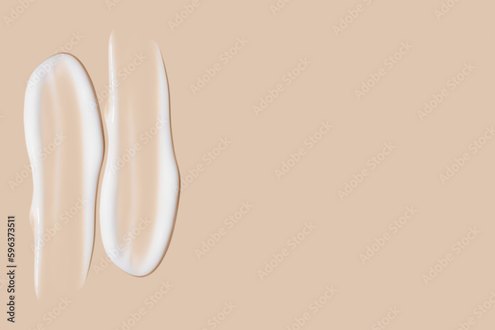 Fototapeta premium a set of strokes of white cream on a beige background.