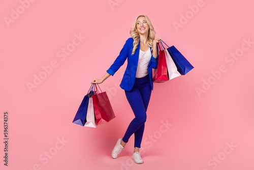 Full size photo of stunning business lady hold shop store packages look empty space interested isolated pink color background