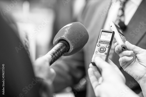 News or press conference or media interview, digital voice recorder and microphone in focus photo
