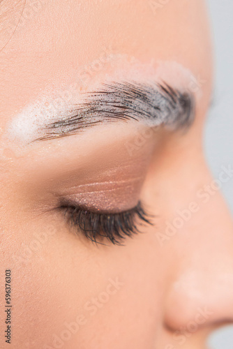 Macro of eyesbrows undergoing correction and long-lasting styling, shaping the eyebrows, eyebrows in foam. Selective focus, close up