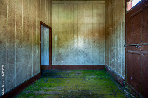 Interior de um amplo quarto vazio de uma casa de madeira abandonada