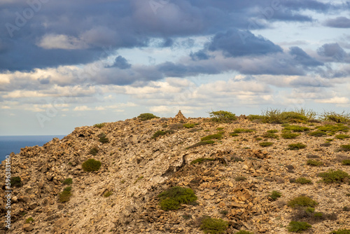 A small stone cairn seen atop a mesa in the desert with blue skuy and white clouds.  room for text photo