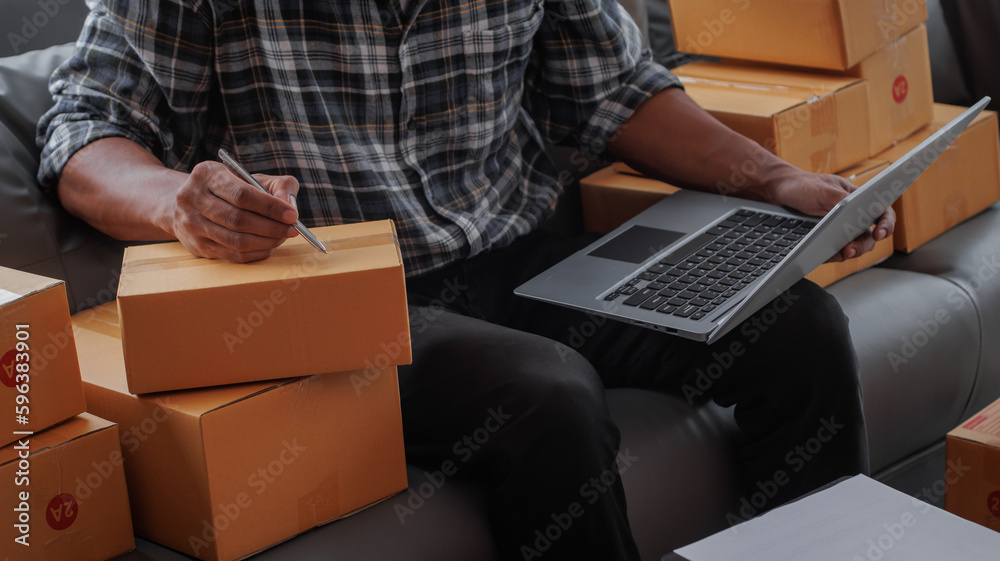 Entrepreneurs Small Business SME Independent men work at home Use smartphones and laptops for commercial checking, online marketing, packing boxes, SME sellers, concept, e-commerce tea Entrepreneurs Small Business SME Independent men work at home Use smartphones and laptops for commercial checking, online marketing, packing boxes, SME sellers, concept, e-commerce tea