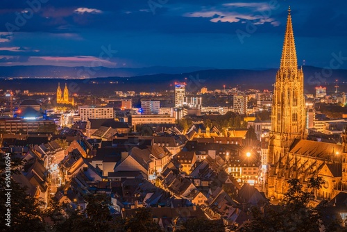 Fototapeta Naklejka Na Ścianę i Meble -  Blick auf die Stadt Freiburg (Deutschland) von oben bei Sonnenuntergang und aufziehendem Gewitter über den Vogesen