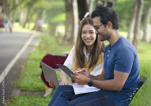 young asian couple casual studying or working outdoors in the park on weekend
