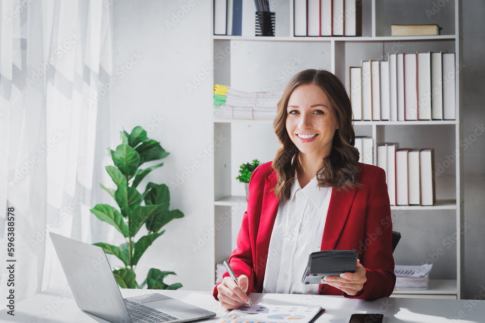 Happy Business woman entrepreneur holding calculator working sit at office desk. Portrait of beautiful smiling young businesswoman working at modern work station. - obrazy, fototapety, plakaty 