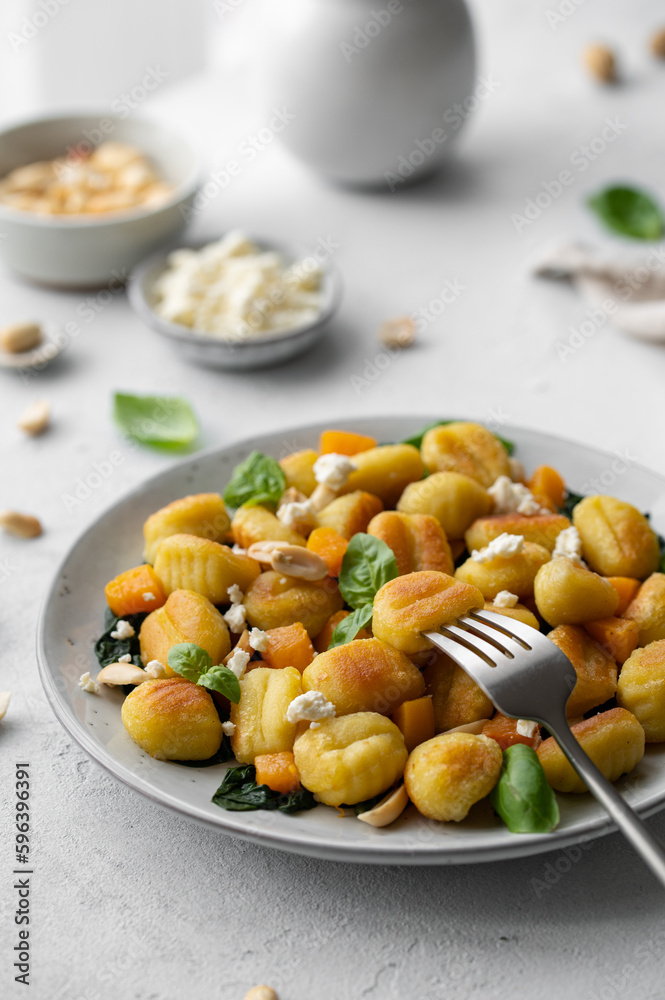 Fried Italian potato gnocchi with cheese and herbs on a white background. Italian food