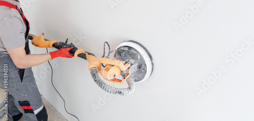 Foto Man worker Painter work with white wall polishing and sanding surface after putt