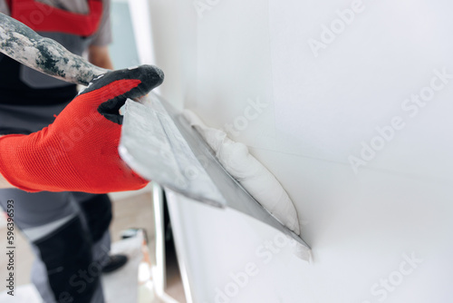 Tableau sur toile Master working with plasters on white walls and putty screeds after installing d