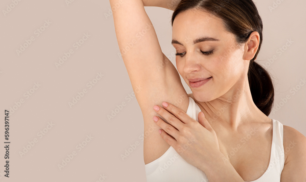 Closeup of young smiling woman touching her armpit Closeup of young smiling woman touching her armpit