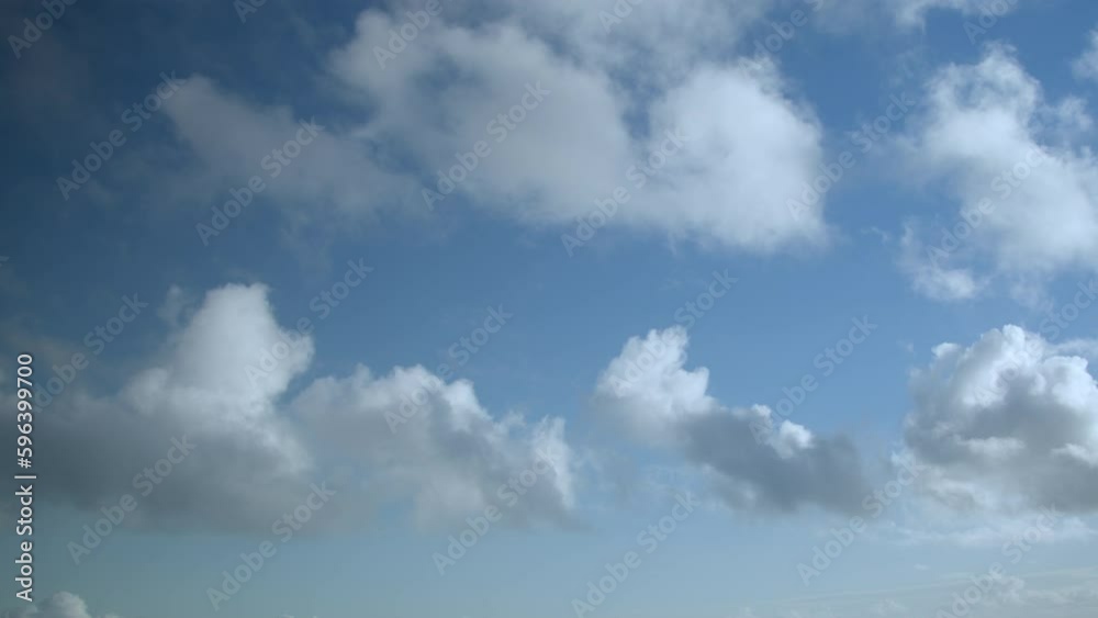 White fluffy cumulus clouds are flying fast in a clear blue sky, video timelapse, sky as a background. White fluffy cumulus clouds are flying fast in a clear blue sky, video timelapse, sky as a background.