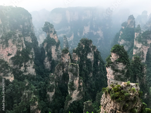 Avatar Zhangjiajie National Park mountains with fog during a beautiful morning with a green forest landscape in the background.