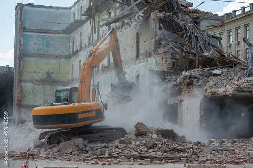 Demolition of building. Excavator breaks old house. Freeing up space for construction of new building