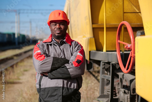 Railroad man in uniform and red hard hat look at the camera photo