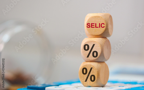 SELIC. A sigla selic e o símbolo de porcentagem em dados de madeira que estão sobre uma calculadora. Economia Brasileira. photo