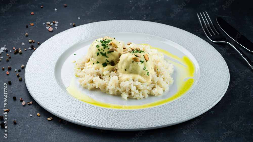 Lunch pork meatballs with rice, milk sauce, seeds and herbs.