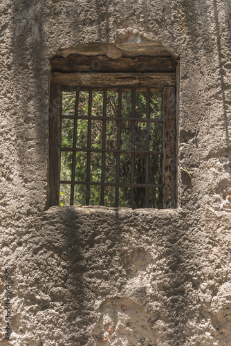 Window of an old house in a wall of adobes and quarry. © Marco