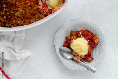 Bild auf Leinwand Home made Rhubarb and Strawberry crumble with rolled oats and vanilla ice cream scoop