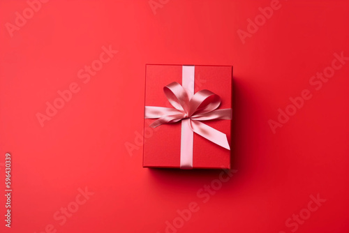 Gift box with satin ribbon and bow on red background. Holiday gift with copy space. Birthday or Christmas present, flat lay, top view. Christmas giftbox concept